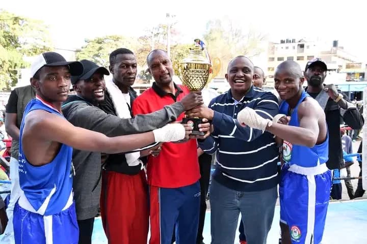 ORTBC boxers holding a championship trophy with their coach